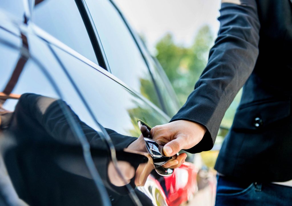 chauffeur opening the door to take passenger to Geneva Airport